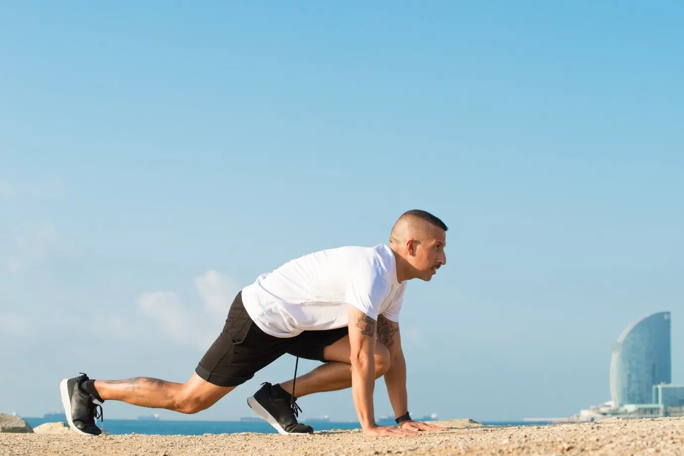 An aspirated runner in a starting stance on the beach